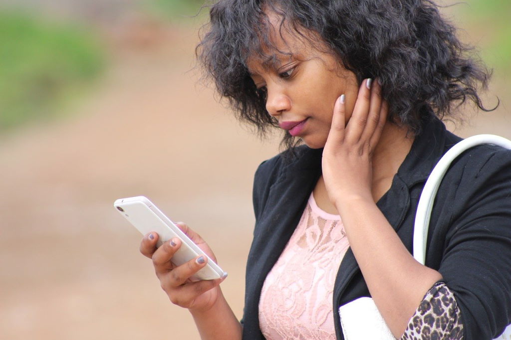 A female person looking at a smart phone screen