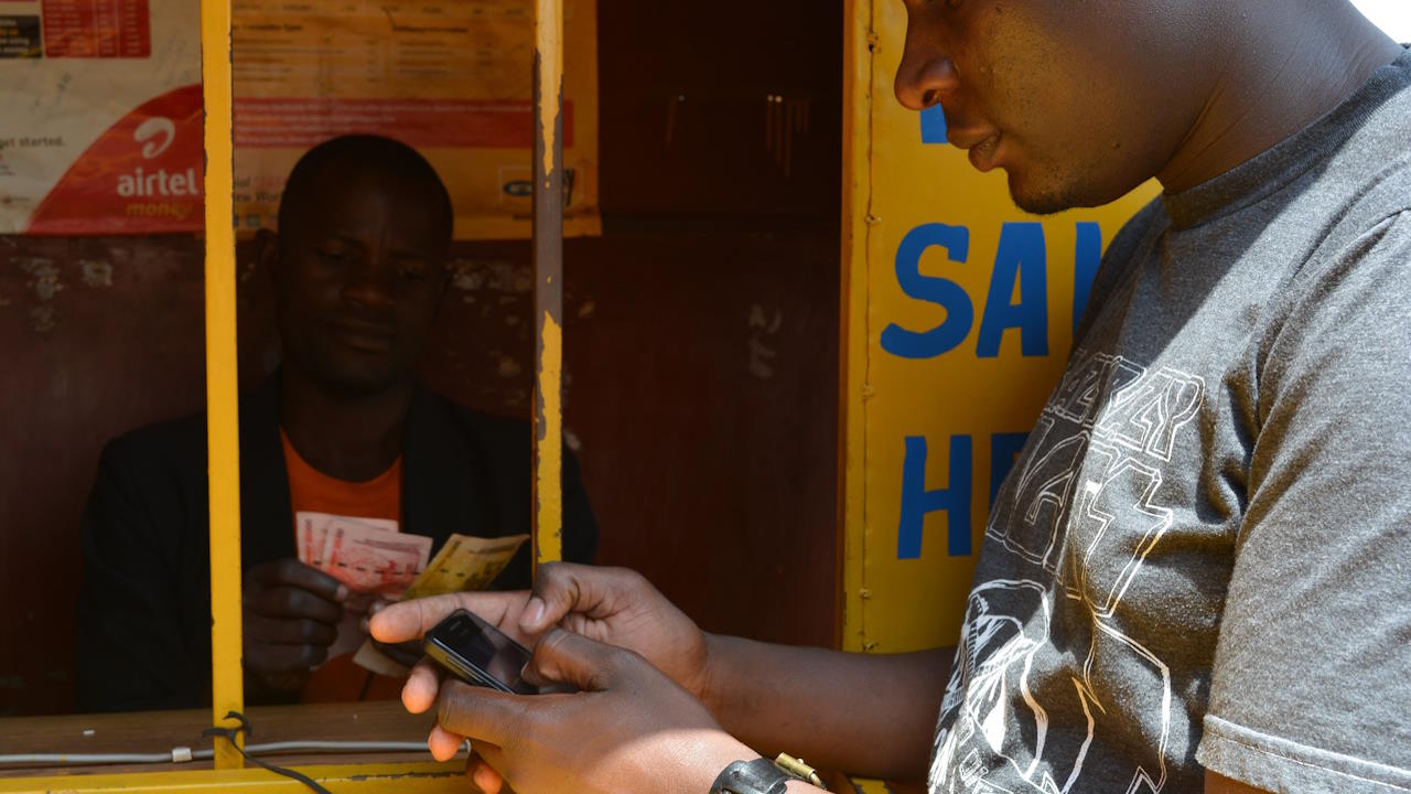 A person withraws money from their mobile money account in Uganda