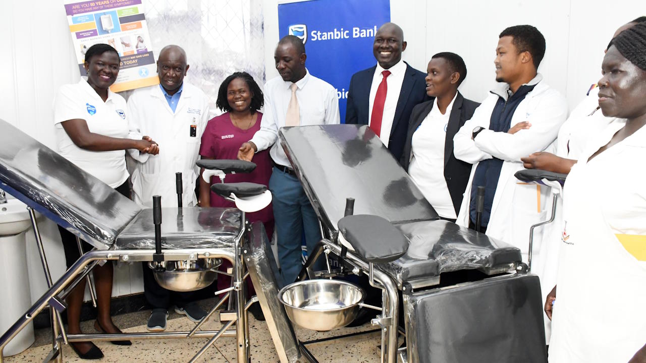 A group of bankers and health workers at a hospital ward during the handover of equipment