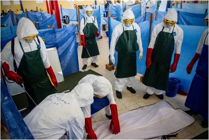 Health care workers learn how to properly dispose of the remains of a simulated patient who died from Ebola