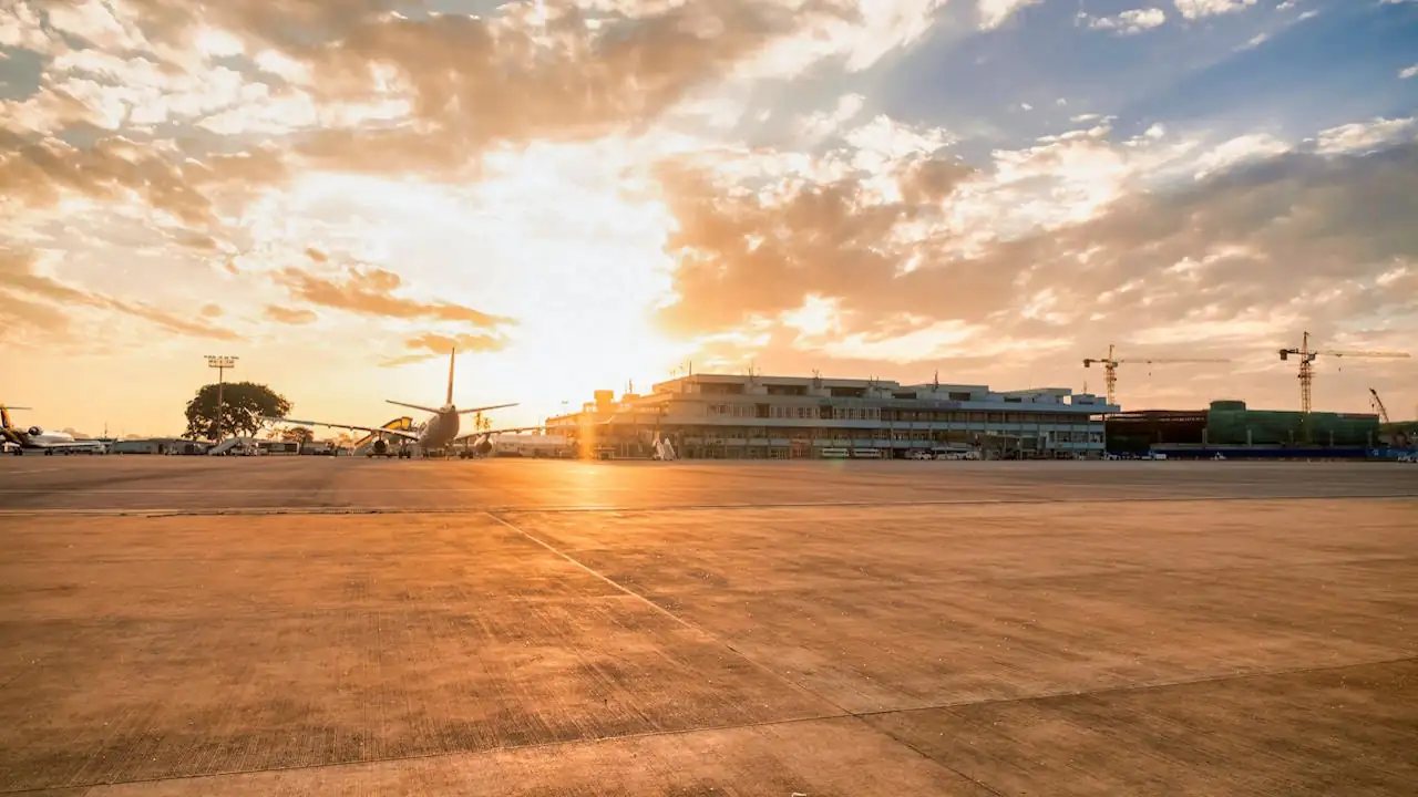 Aircraft parked on the apron at Entebbe International Airport at sunset.