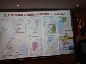 Uganda's minister for energy, Irene Muloni, stands next to a map showing the five oil blocks she had just opened for licensing at the East African Petroleum Conference in Mombasa