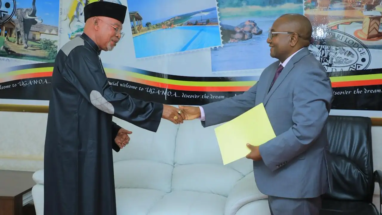 Two men, standing, shake hands at a diplomatic presentation of credentials.