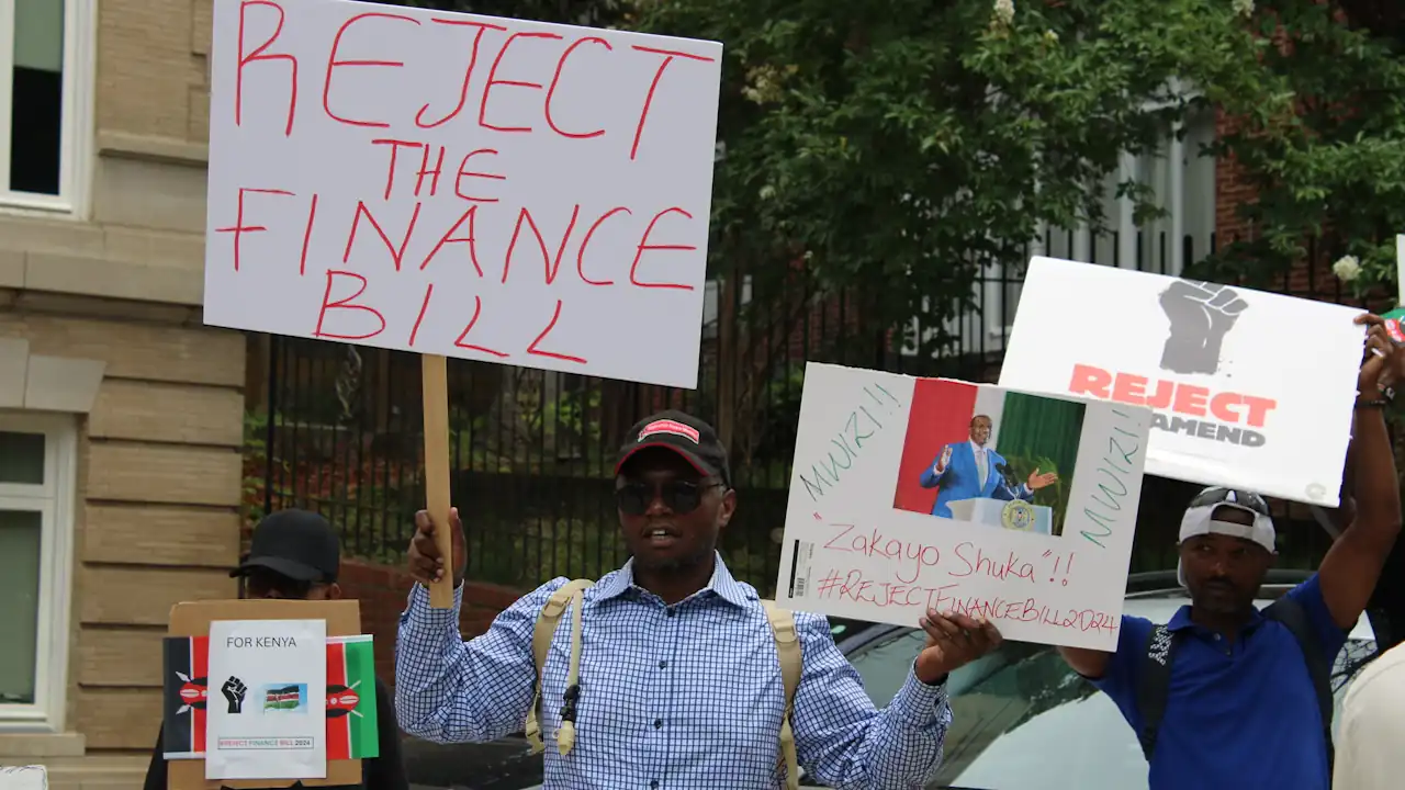Two men hold placards at a demonstration in Washington D.C. in June 2024. They were part of a demonstration by Kenyans living in the United States in solidarity with mass protests then taking place back home.