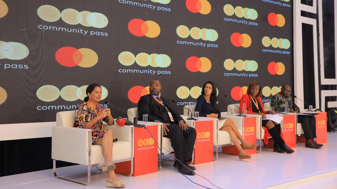Five panelists, including two men and three women, at Mastercard's 2nd Annual Community Pass Customer Summit in Kampala, January 2024. The summit brought together more than 90 public and private sector partners and more than 20 thought leaders dedicated to creating sustainable solutions for digital and financial inclusion across Africa and beyond.