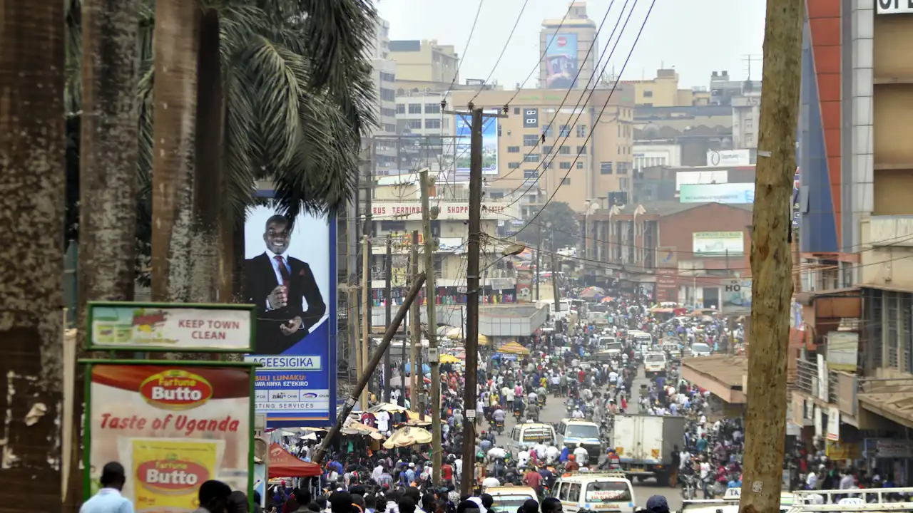 Namirembe road, in downtown Kampala | Uganda Business News A high-angle view of a crowded Namirembe Road in downtown Kampala, featuring a dense flow of pedestrians, commuters, and vehicles amidst commercial buildings and advertising billboards.