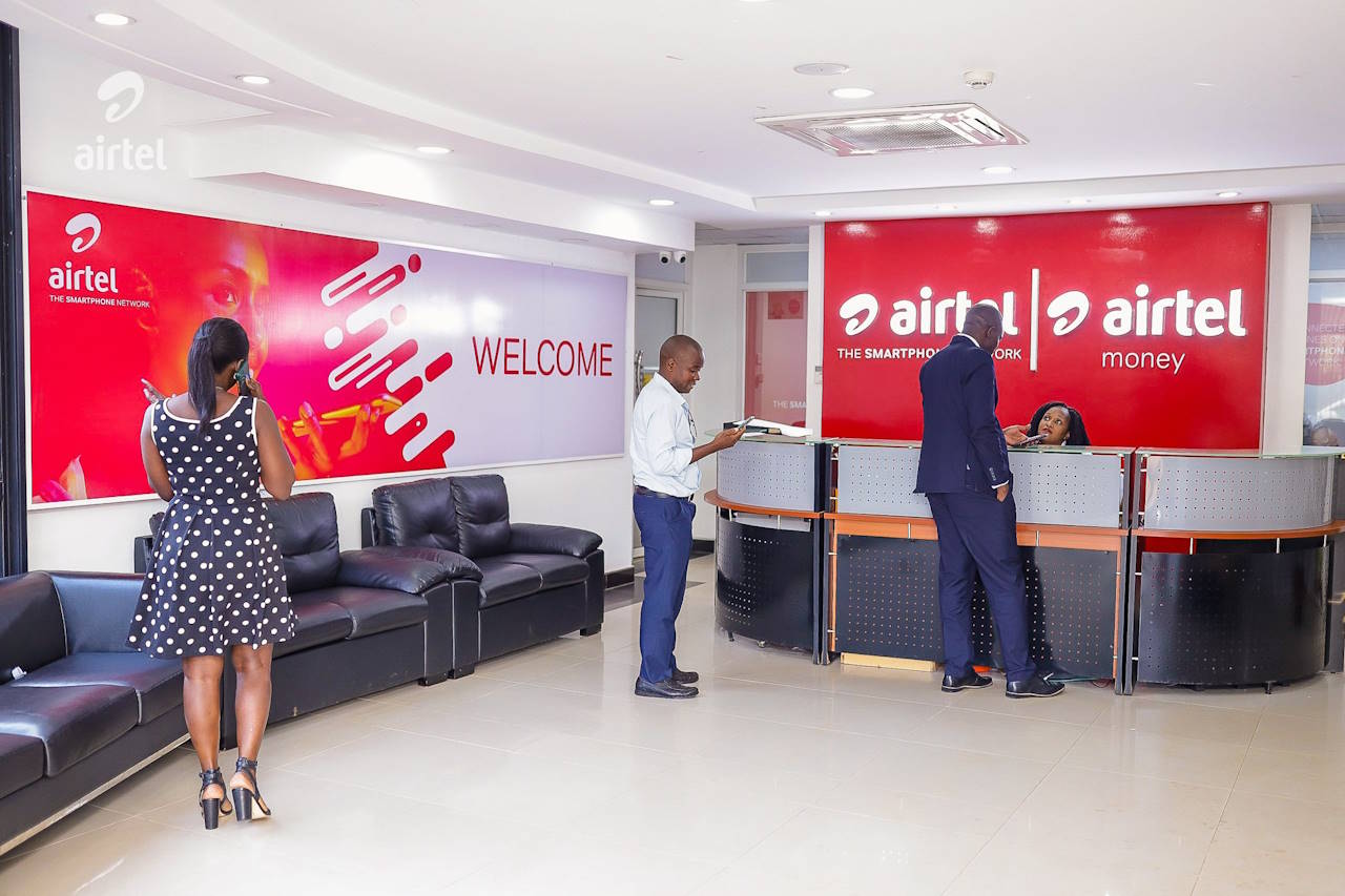 A photo in the reception area of Airtel Uganda's main office on Clement Hill Road in Kampala, and includes four individuals.