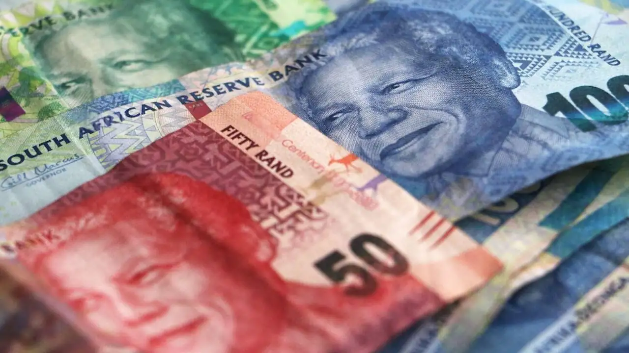 Scattered South African rands notes against a white background.